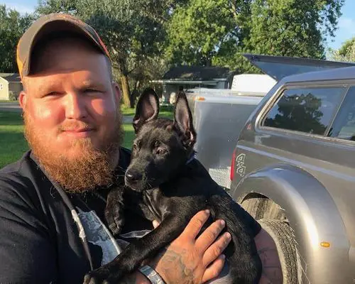 Jake robinson carrying a puppy